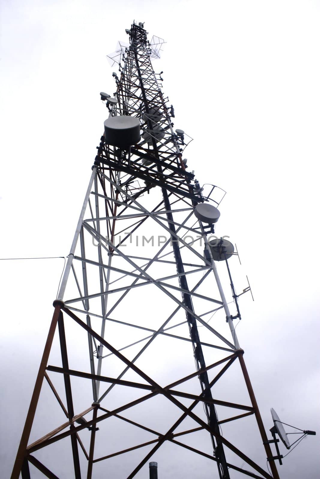 Single communication tower isolated against overcast sky
