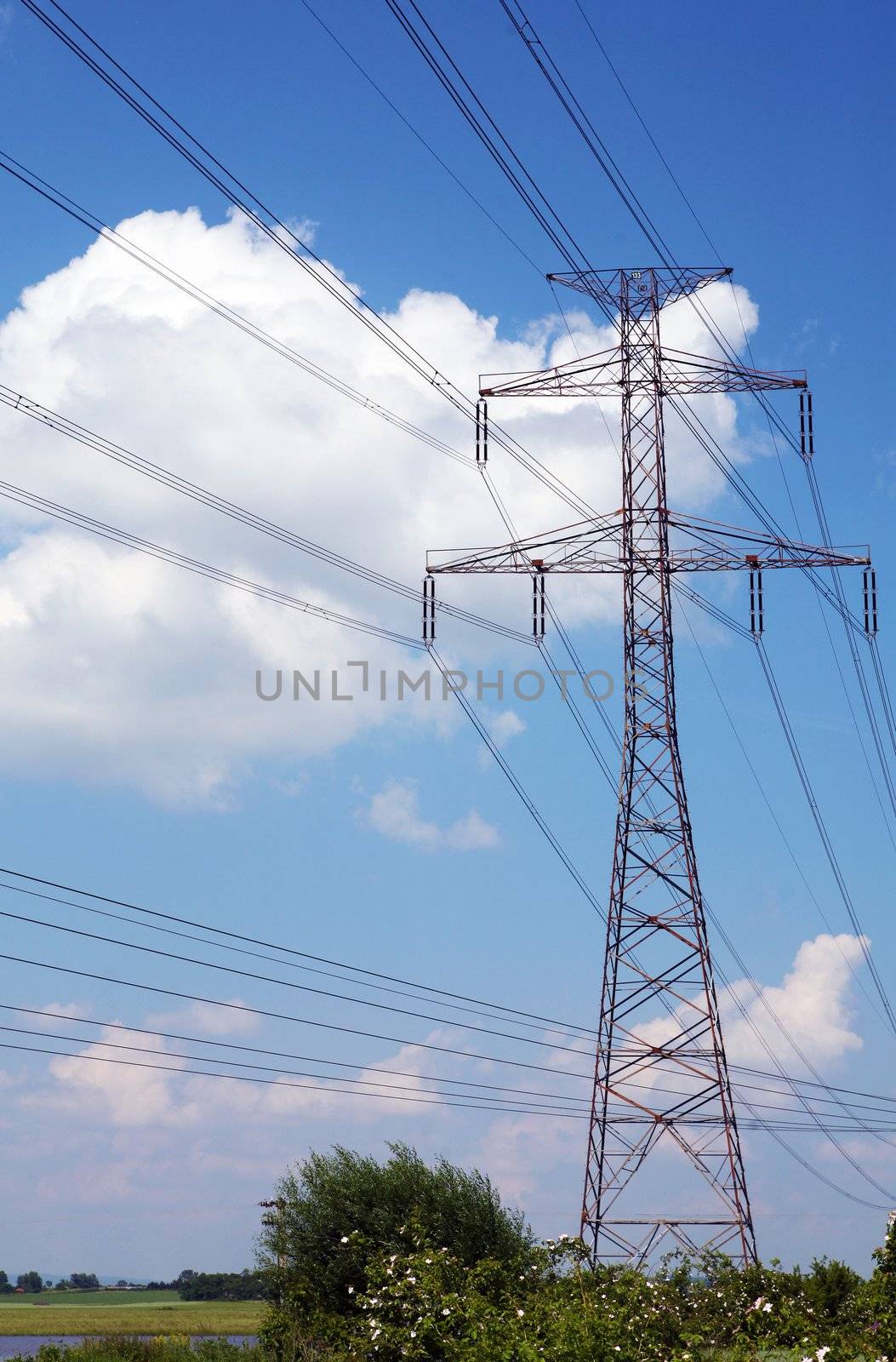 Electric pylons and wires on the cloudy sky