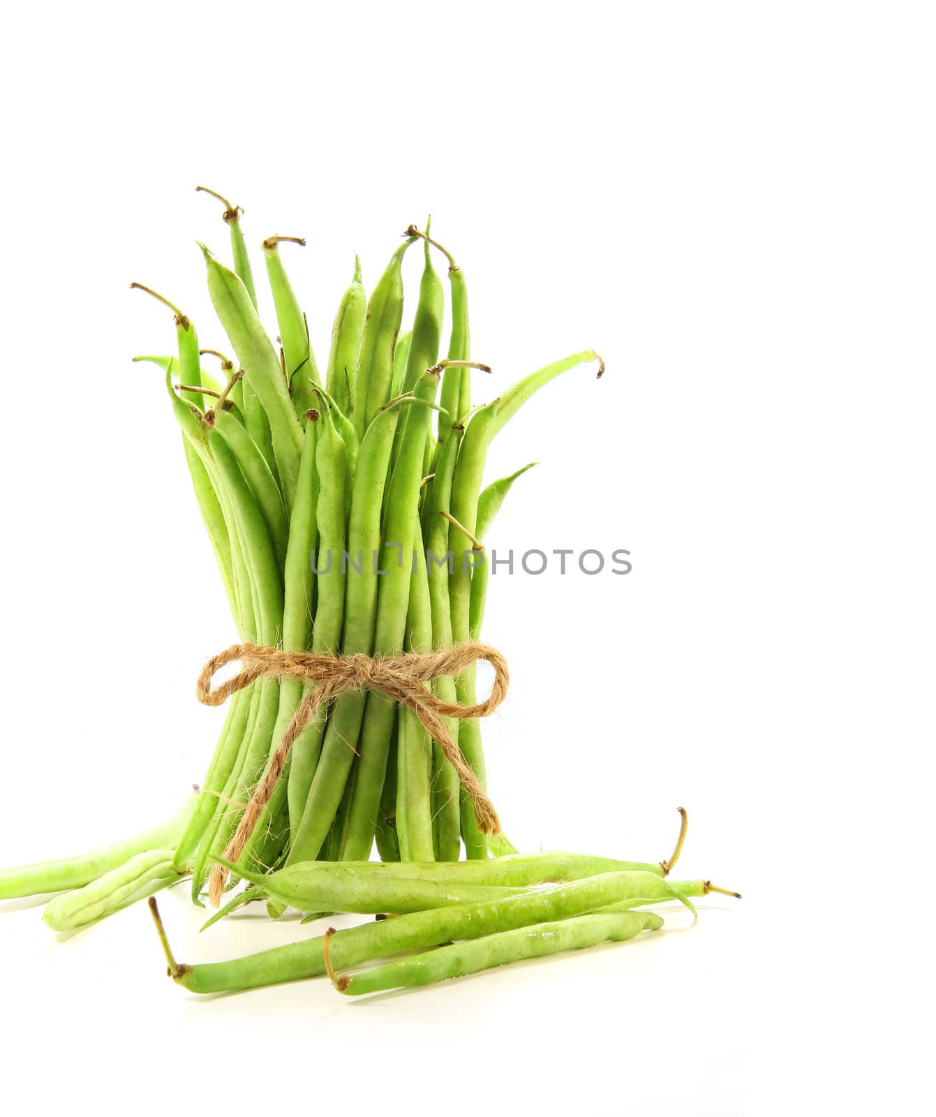 Unwashed green beans tied with cord on white by Sandralise