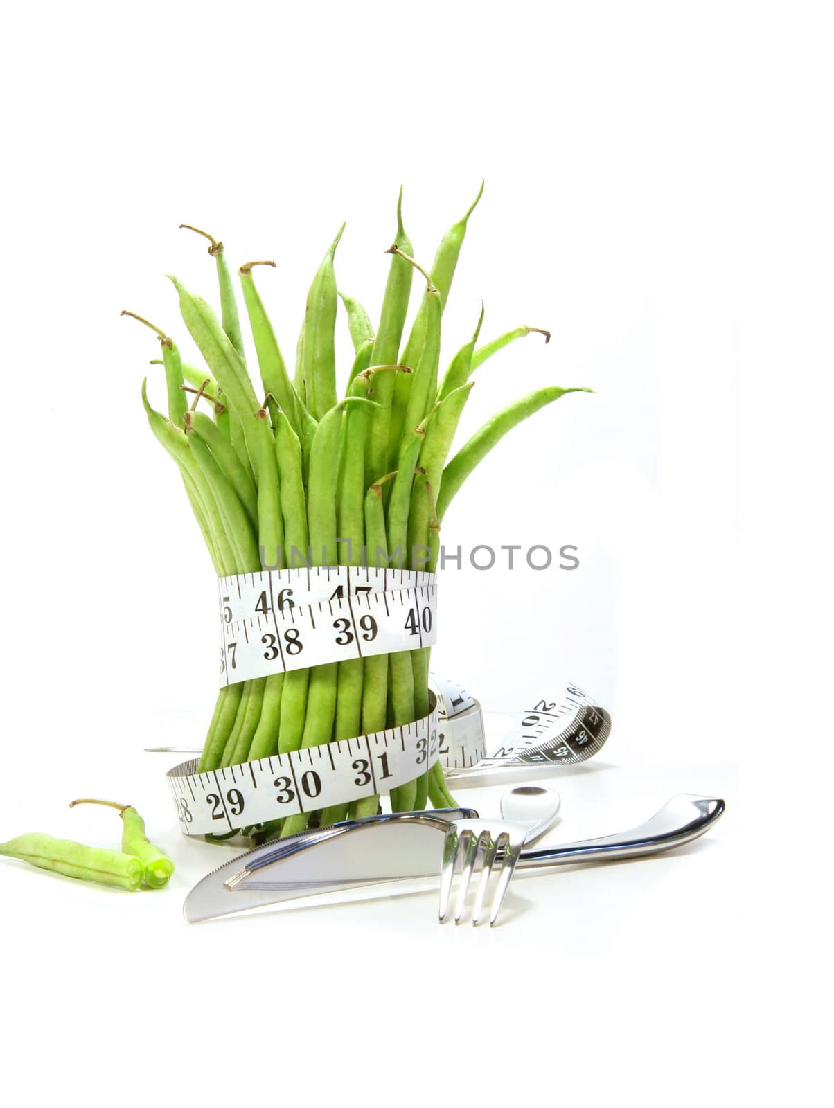 Unwashed green beans with cord and utensils on white