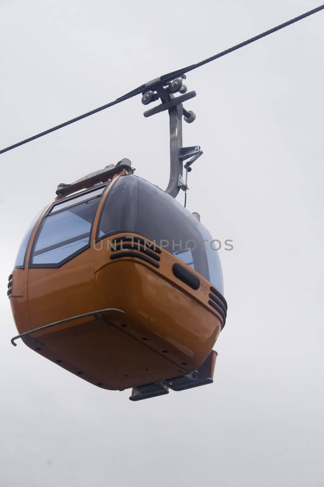 New  orange ski gondola isolated against overcast sky