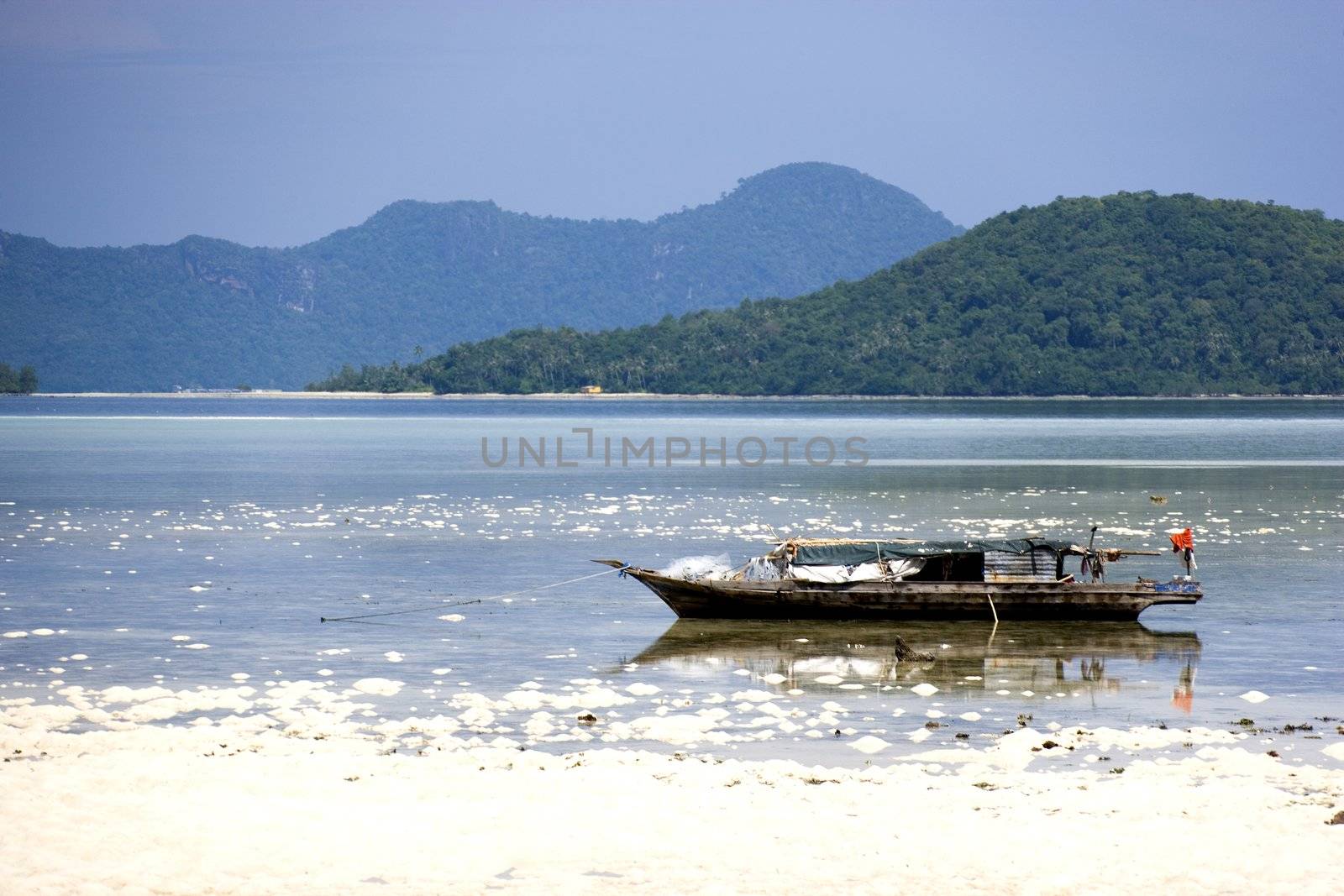 Image of a native fishing boat at low tide.