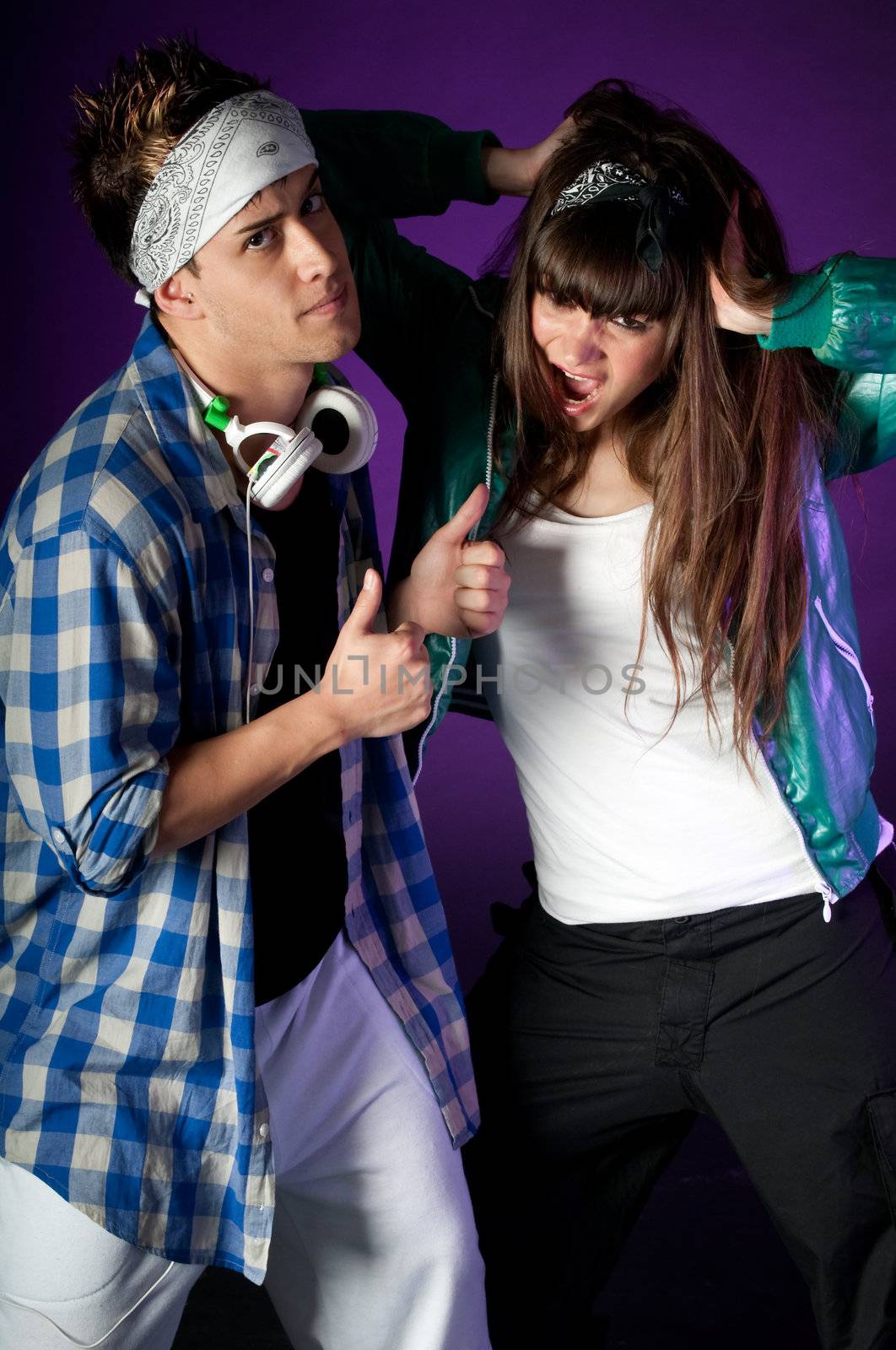 Young urban couple dancers on dark purple light background by dgmata