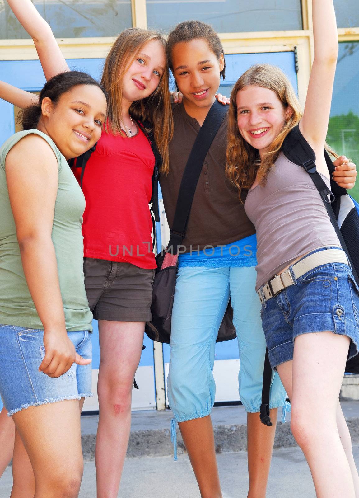 Portrait of a group of four young girls near school building