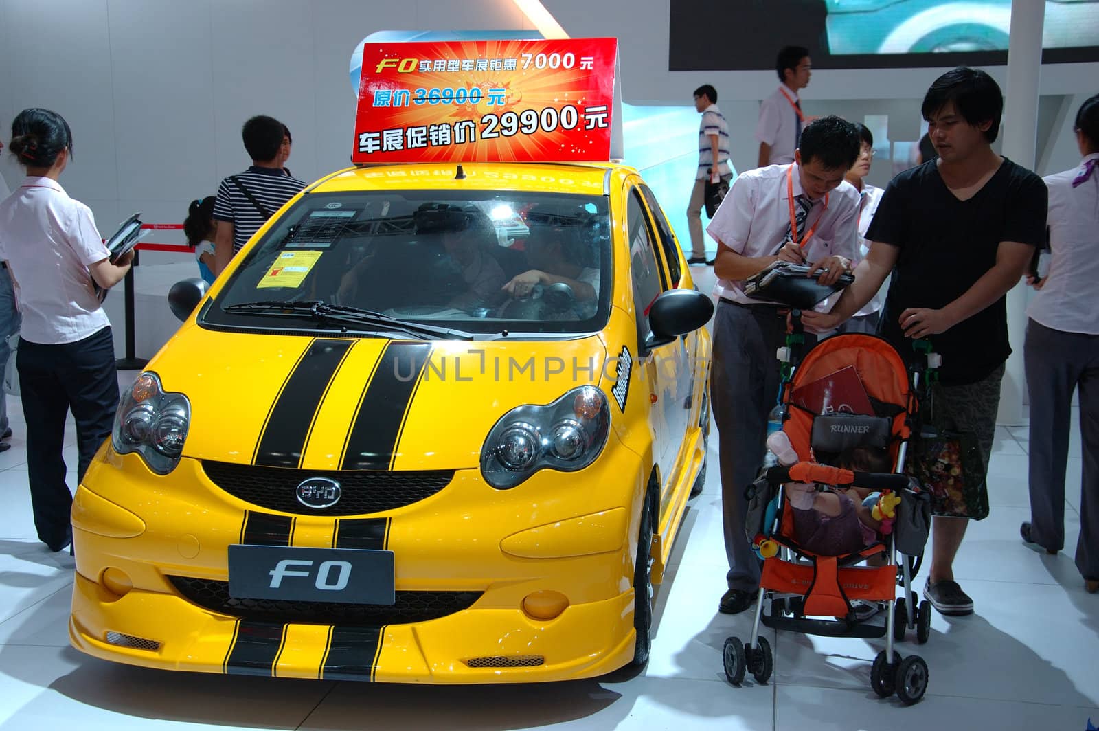 CHINA, SHENZHEN - JUNE 14: Shenzhen-Hong Kong-Macao Auto Show, family watching BYD cars on June 14, 2010 in Shenzhen.