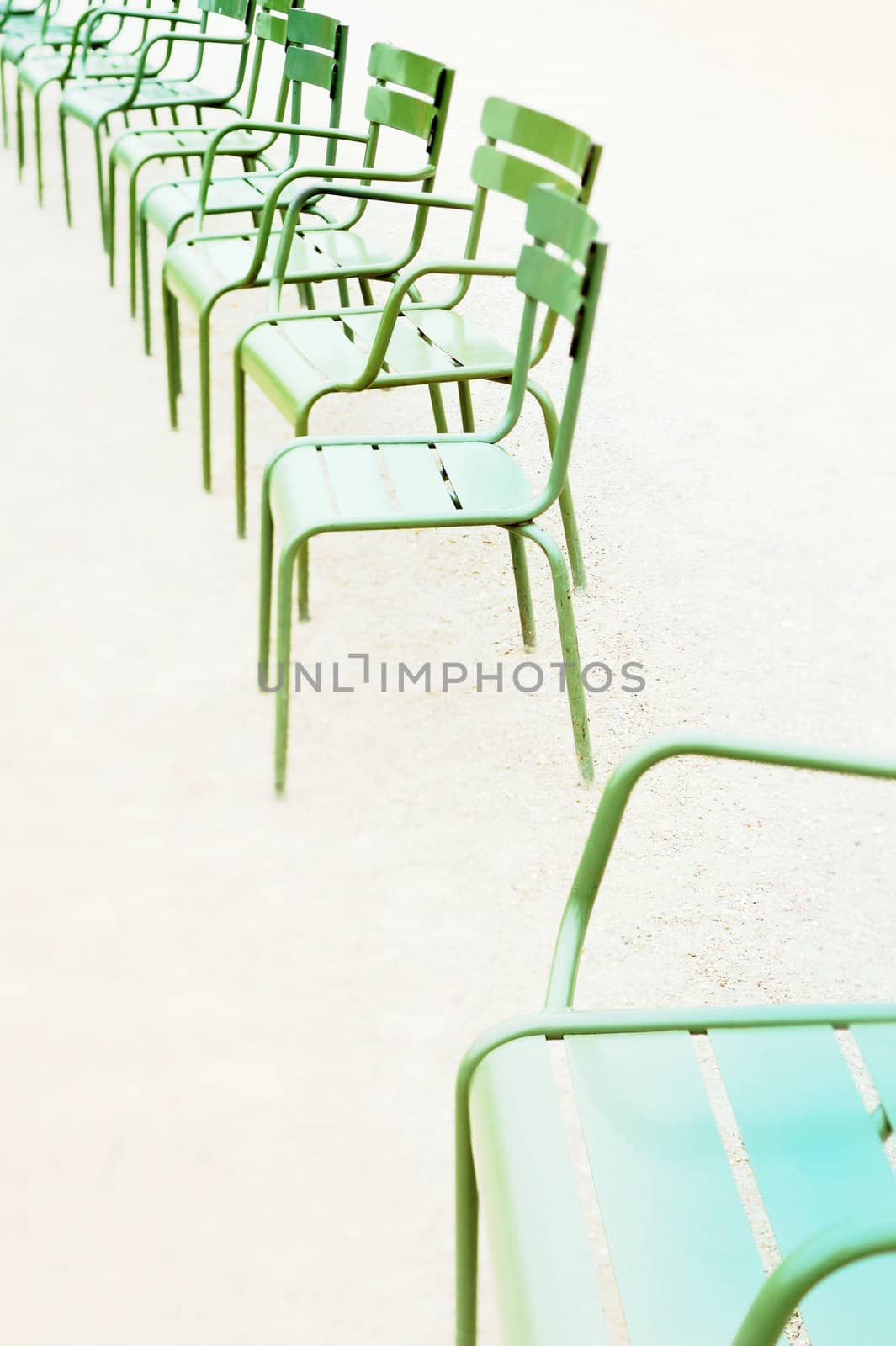 Parisian metallic chairs in the city park. Photo with tilt-shift lens