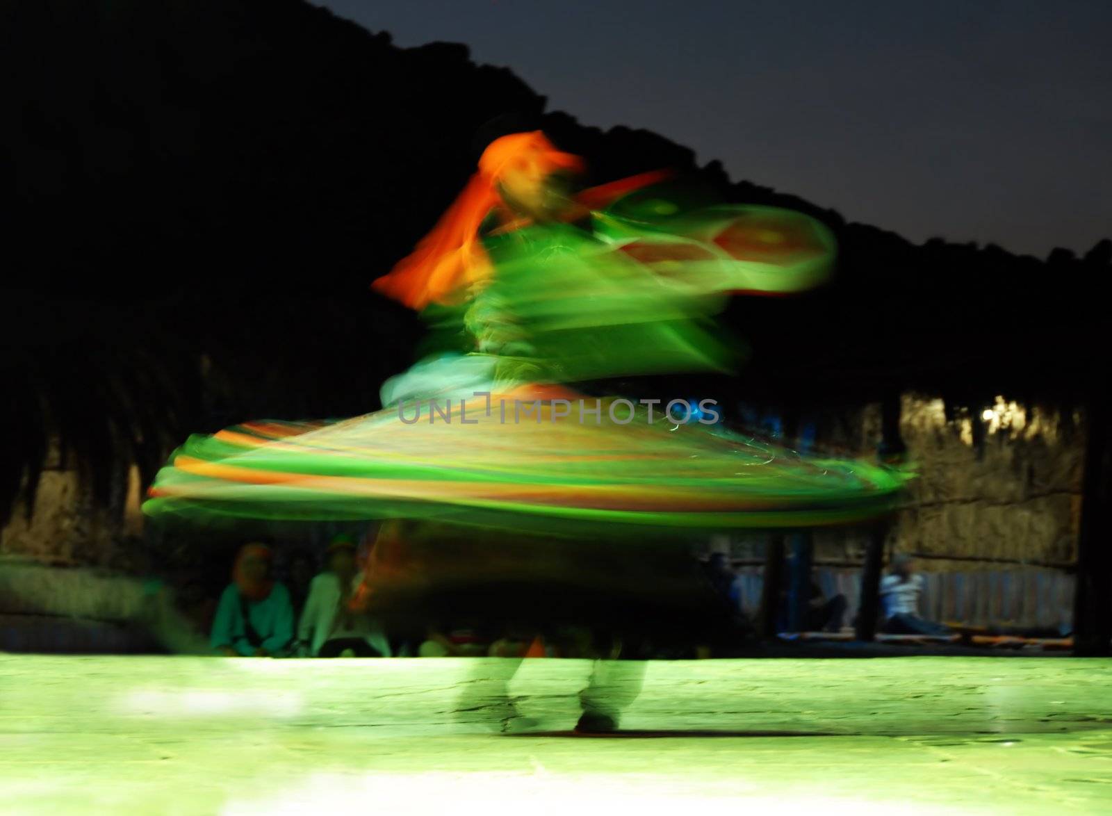 traditional egyptian dancer spinning around in illuminated skirts at night