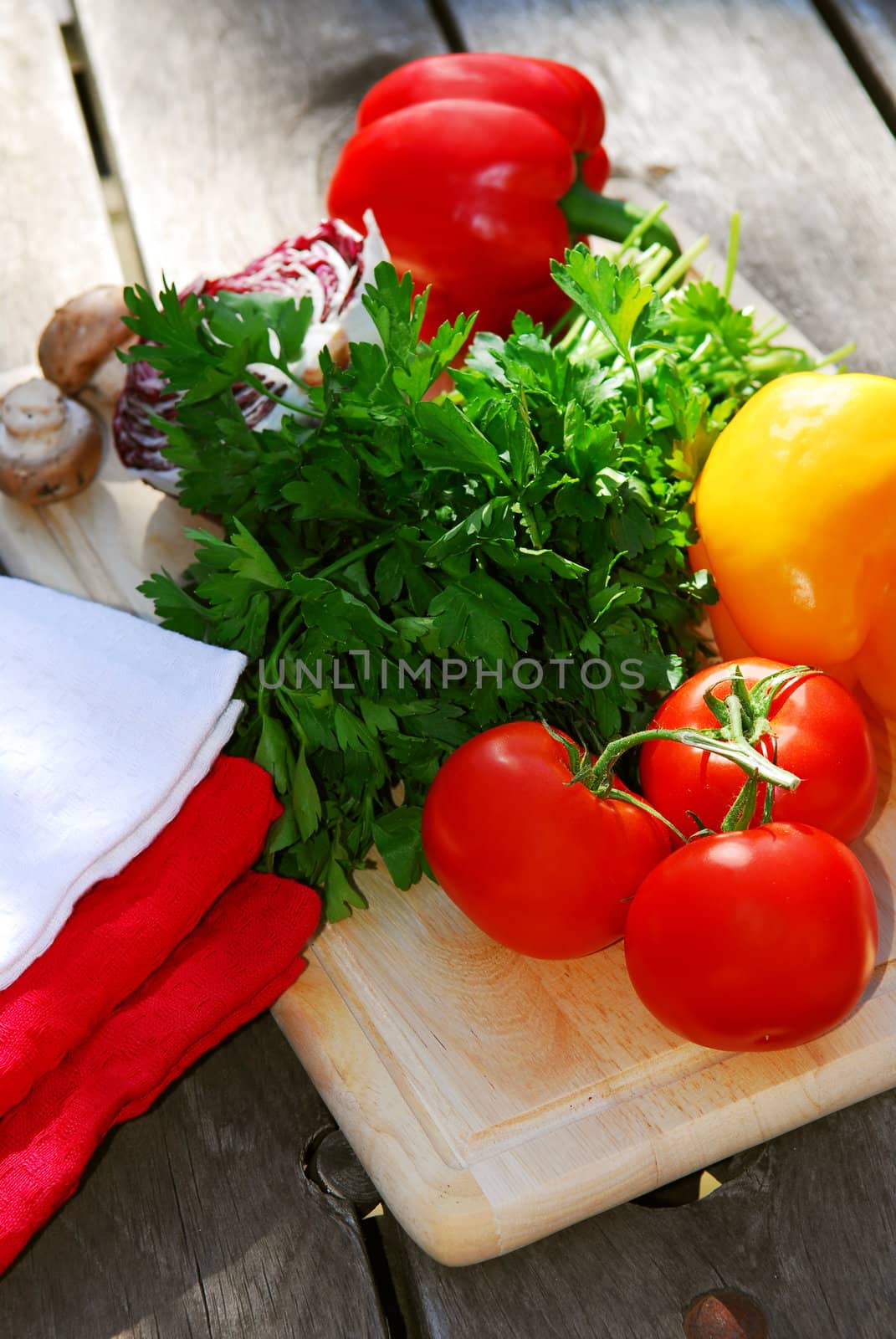 Assorted fresh vegetables on cutting board on rustic table