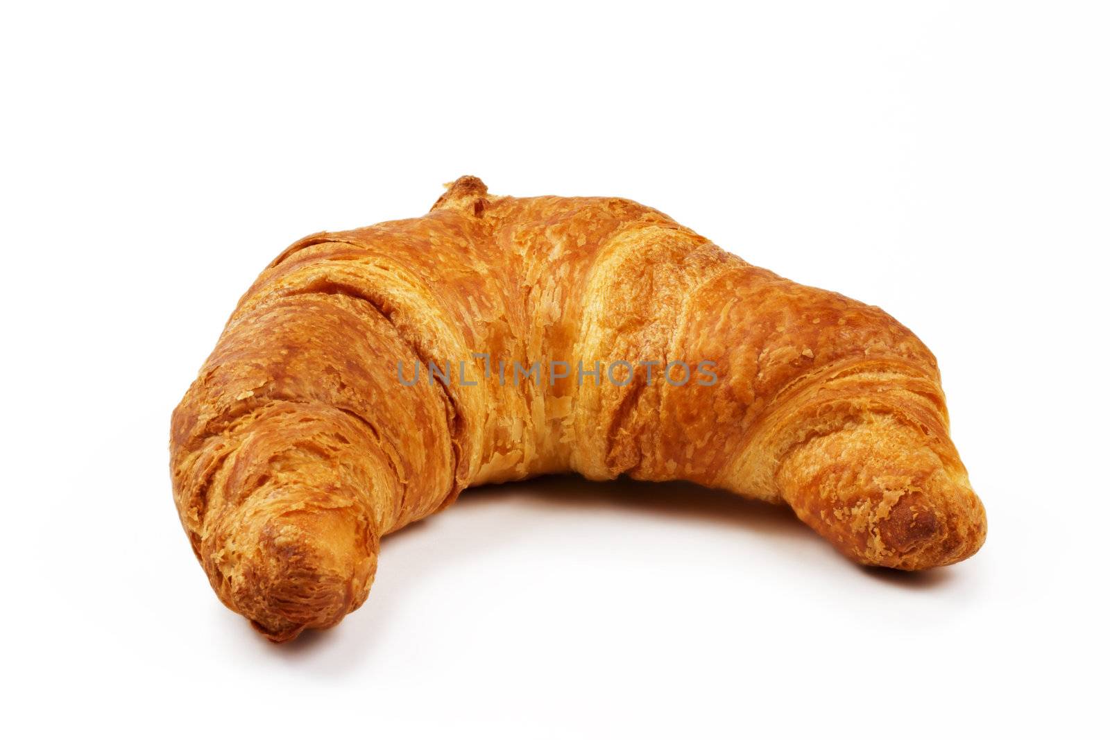 crusty brown croissant on white background