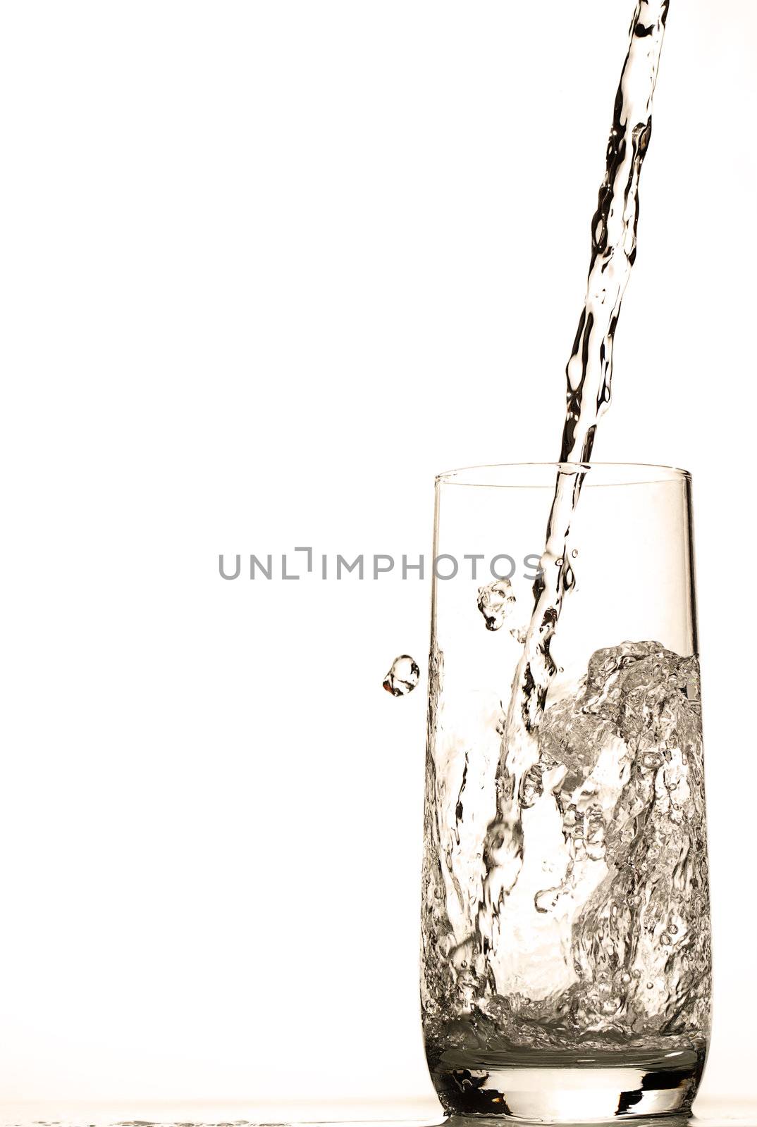 fresh water pouring in glass on white background