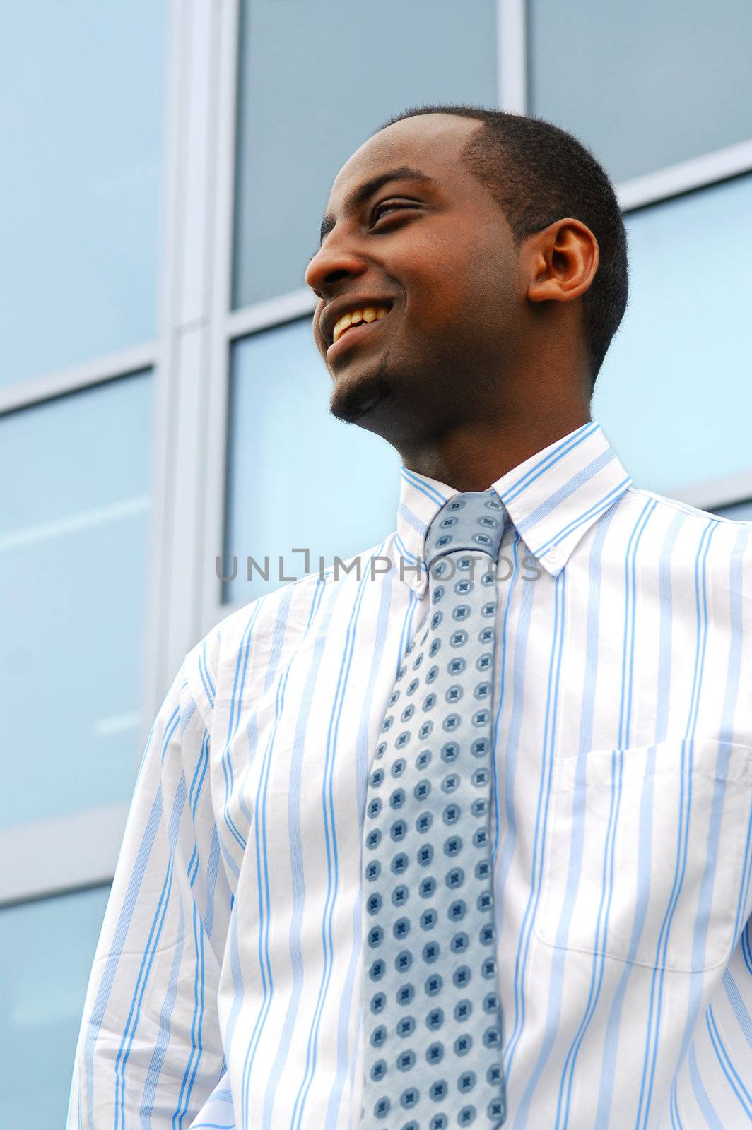 Portrait of a young attractive businessman next to a corporate building