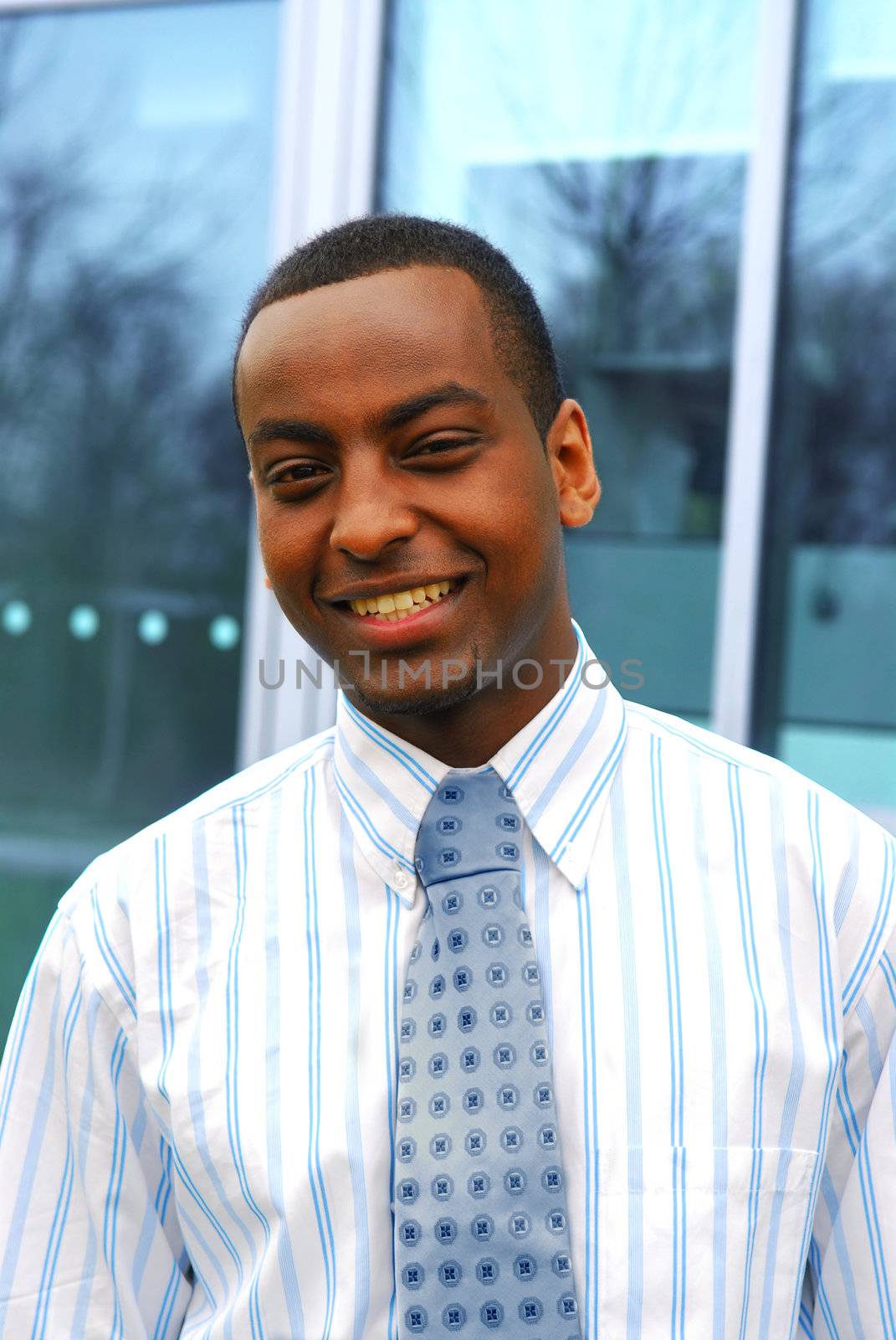 Portrait of a young handsome businessman next to a corporate building