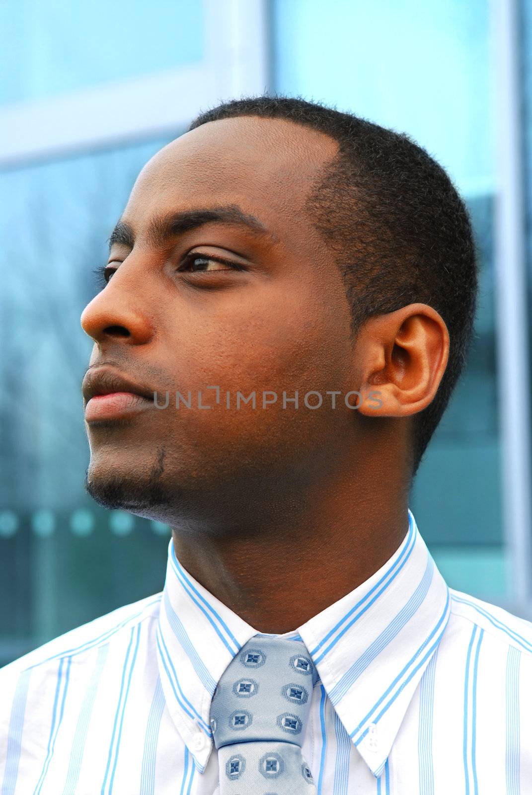 Portrait of a young attractive businessman next to a corporate building