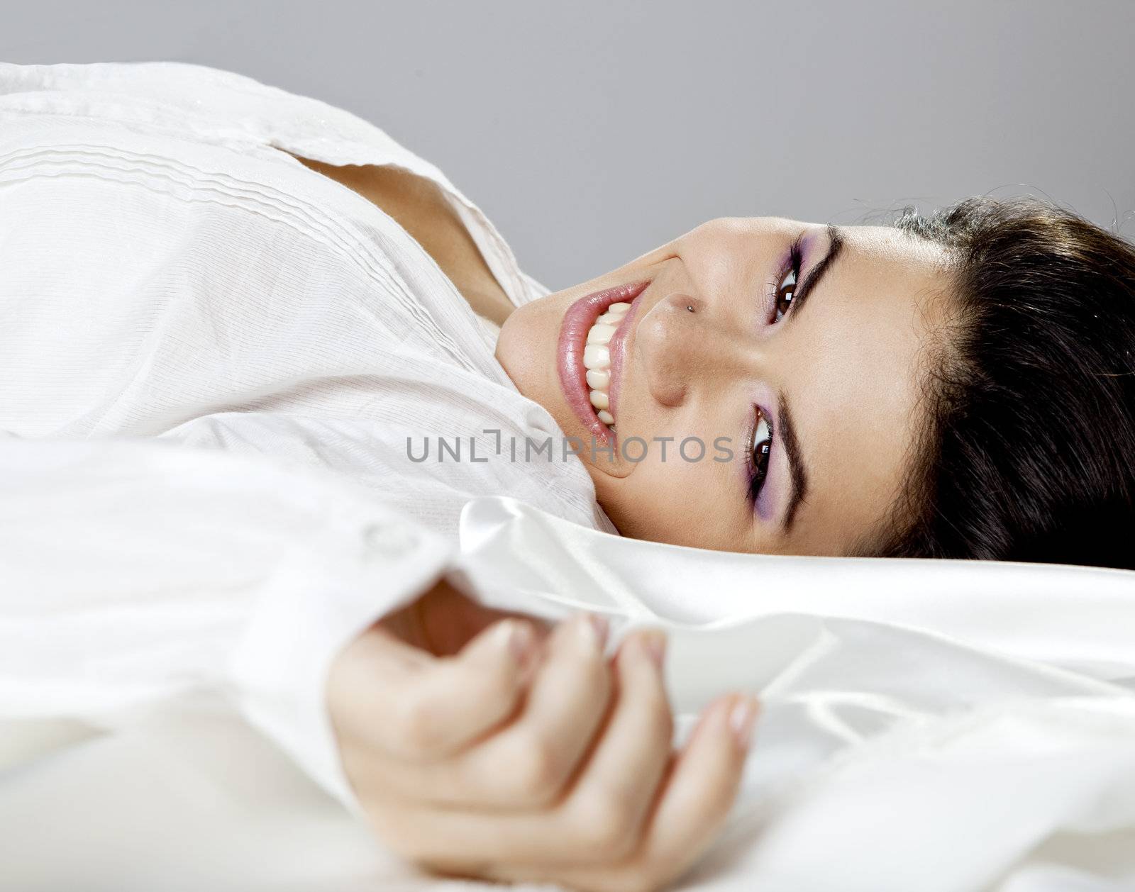 Beautiful young women lying on the bed and smilling