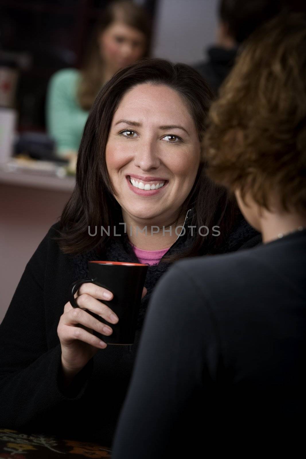 Pretty Hispanic woman in cafe with cup of coffee or tea