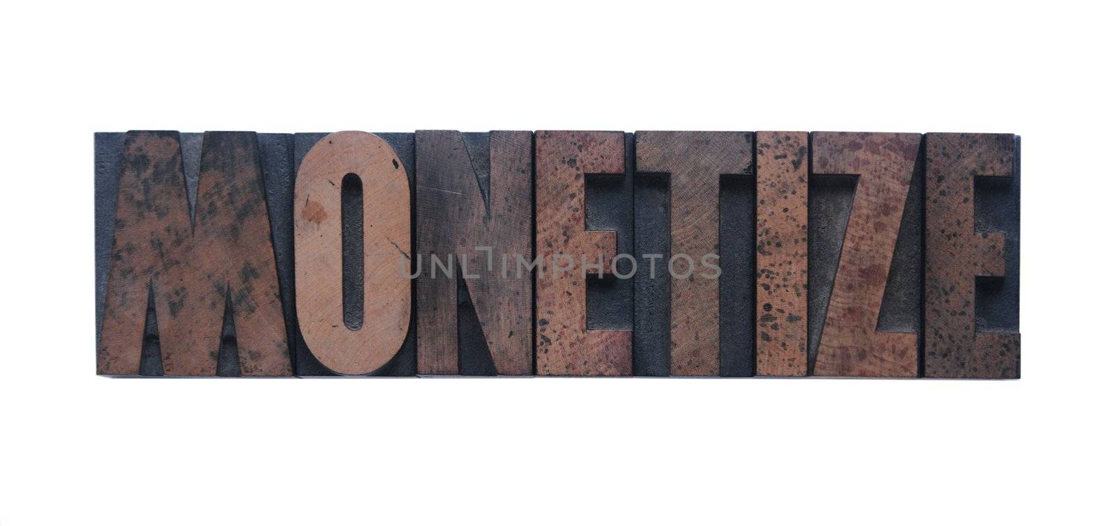 the word 'monetize' in old ink-stained wood type 
