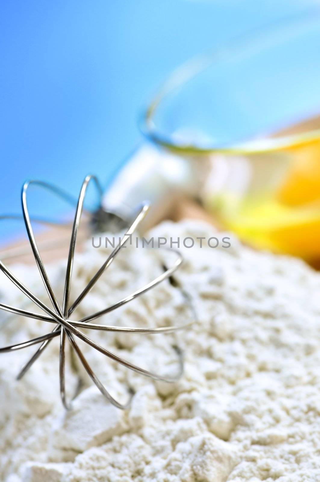 Flour, whisk and eggs in a bowl, baking ingredients