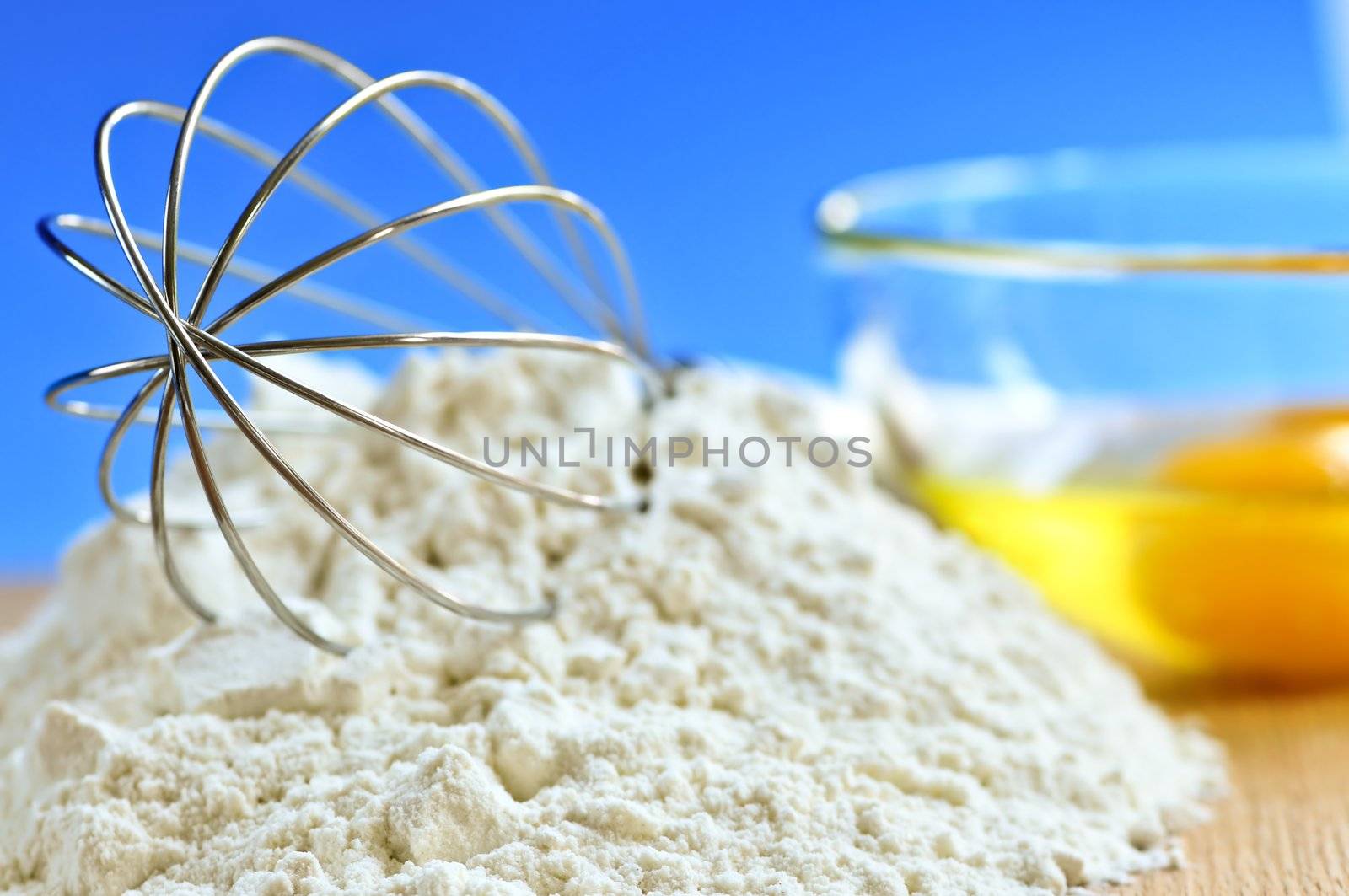 Flour, whisk and eggs in a bowl, baking ingredients