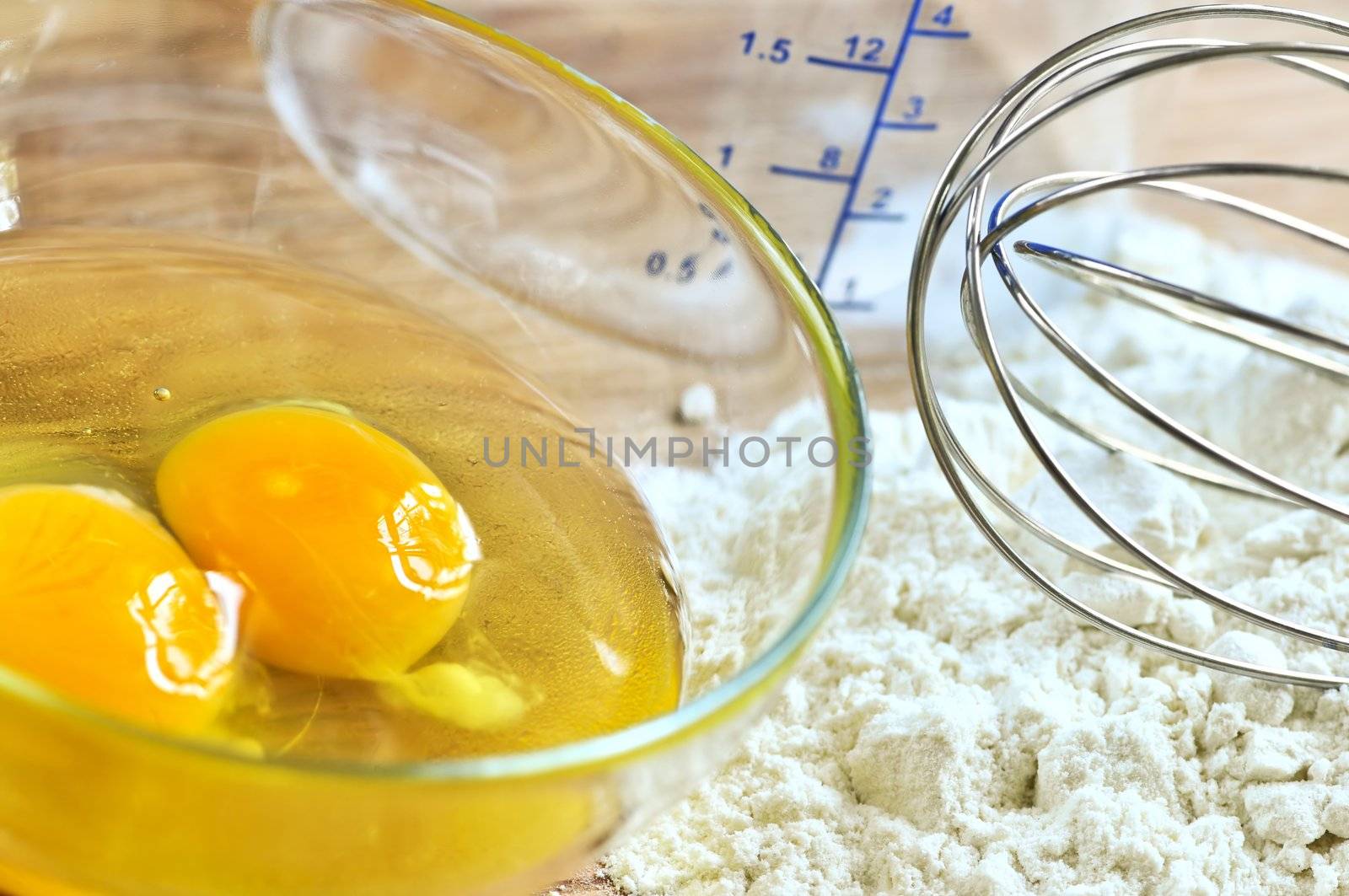 Flour, whisk and eggs in a bowl, baking ingredients