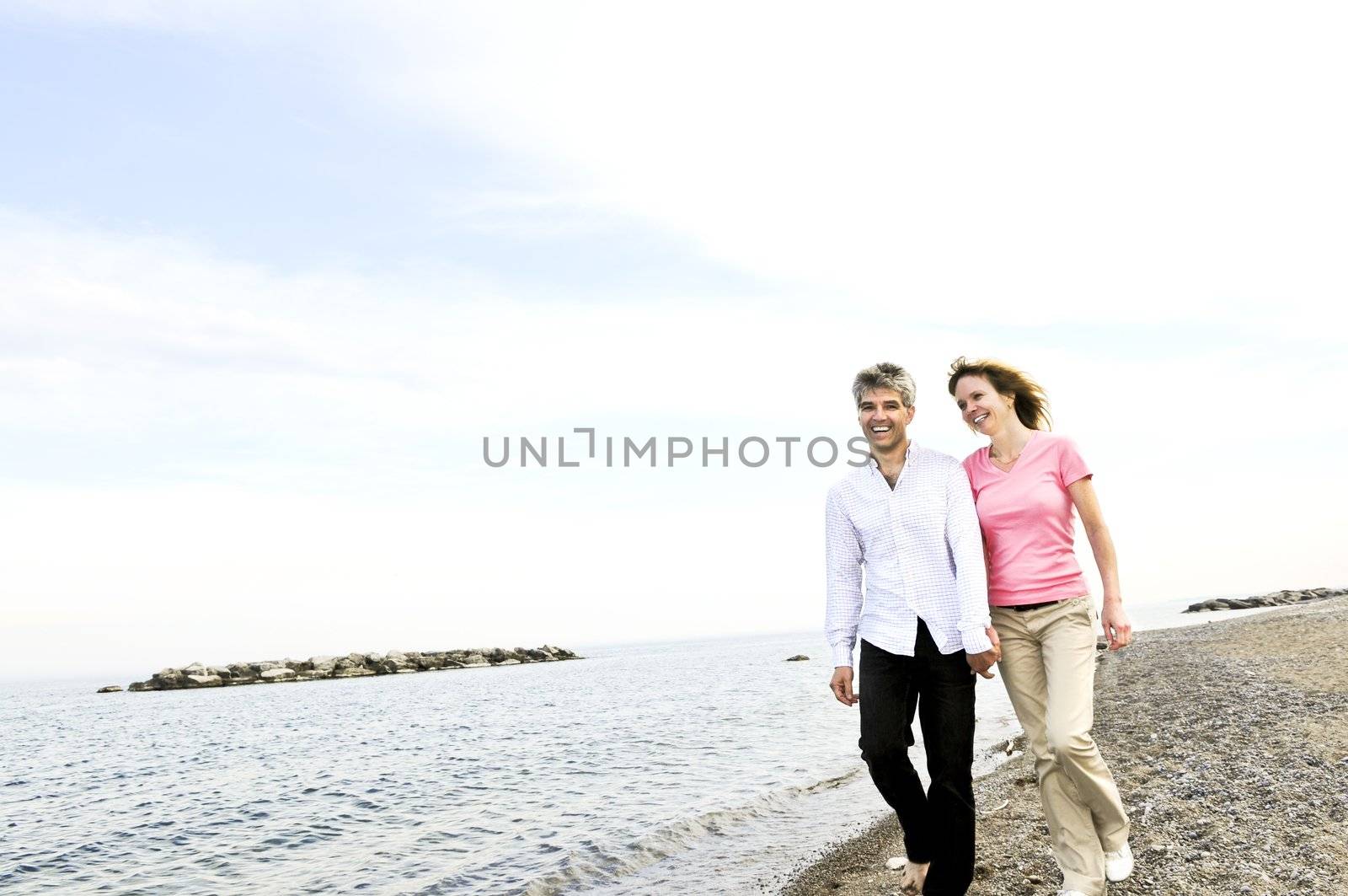 Mature romantic couple walking on a beach