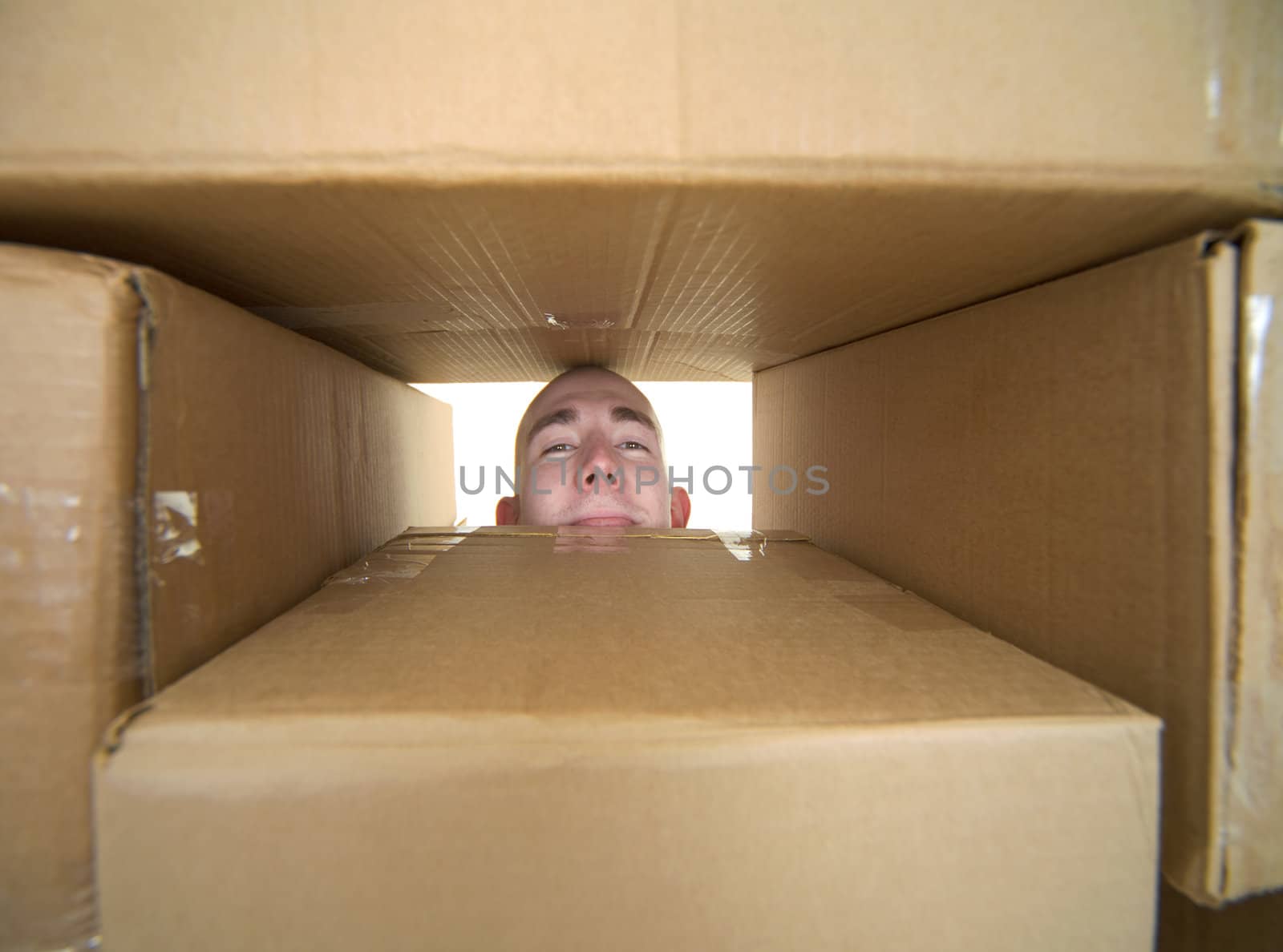Face looking trough window in pile cardboard boxes by pzaxe