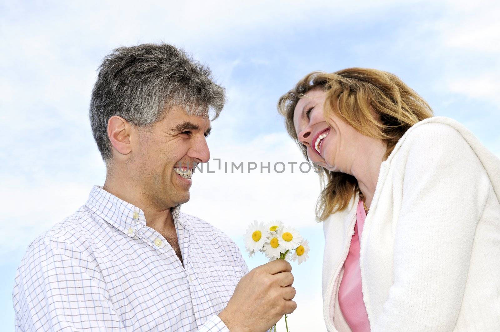 Mature romantic couple with flowers by elenathewise