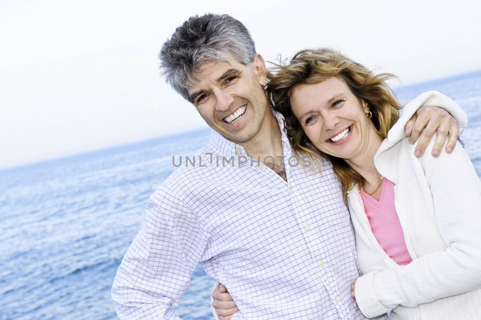 Mature romantic couple at seashore by elenathewise