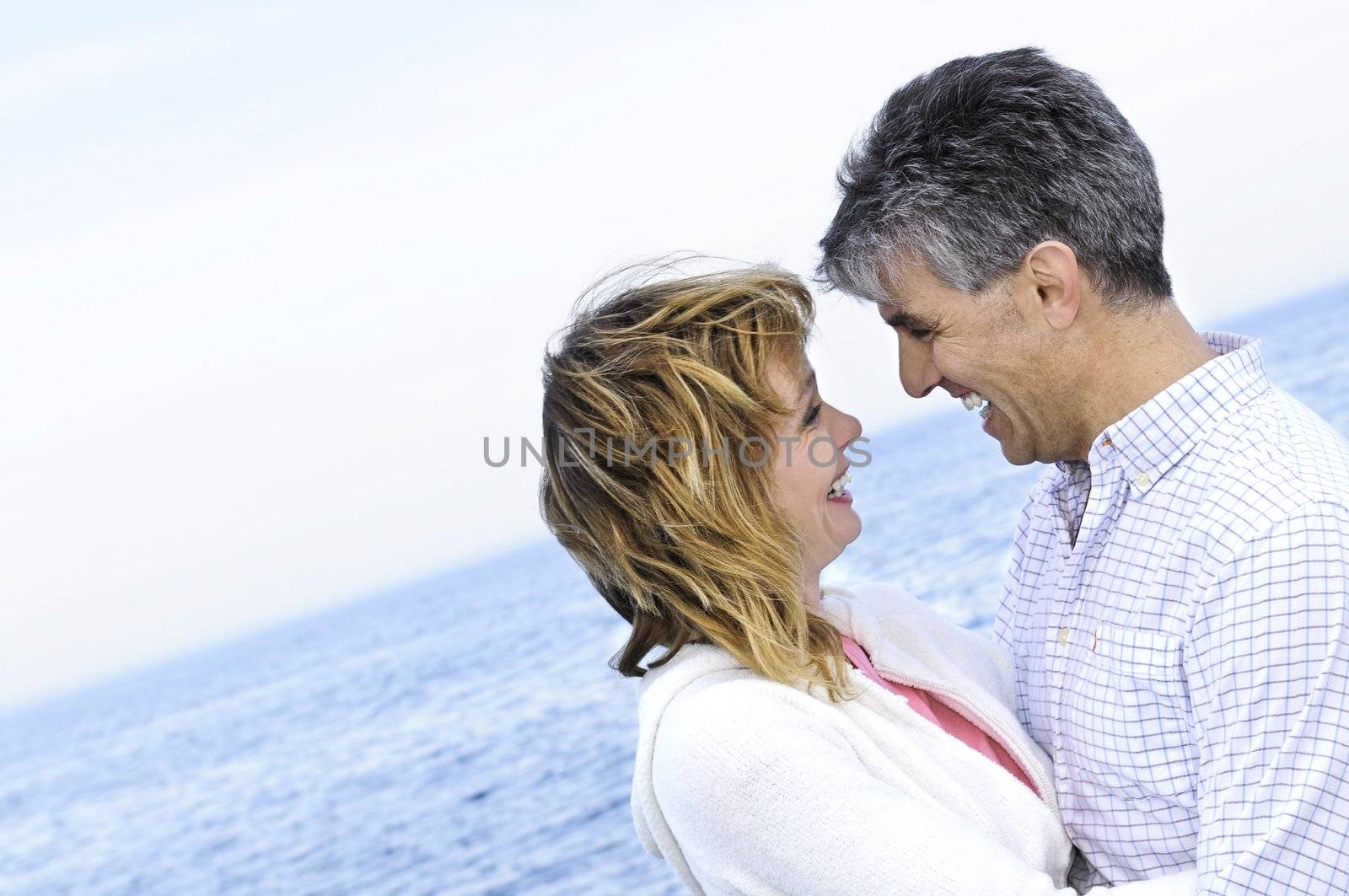 Mature romantic couple at seashore by elenathewise