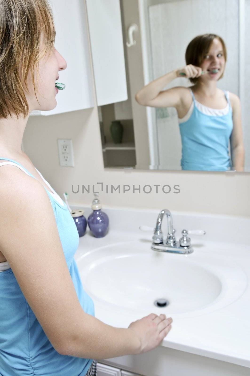 Young girl brushing her teeth in a bathroom