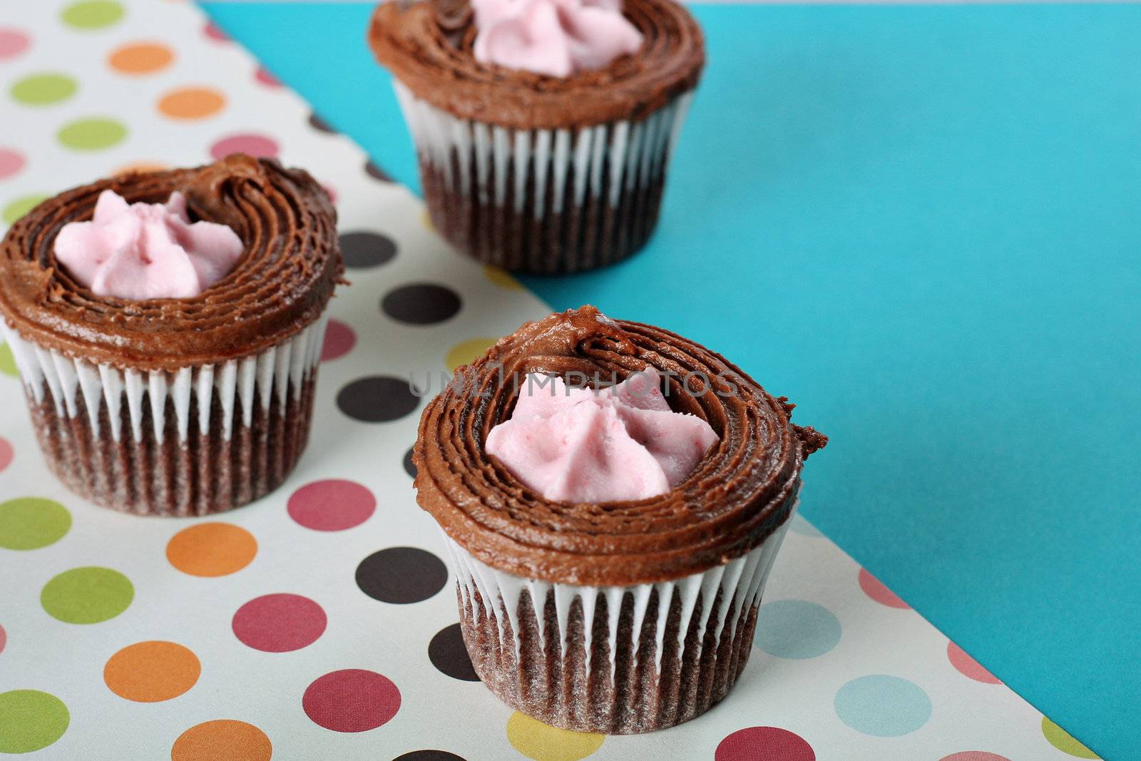 shot of polka dot raspberry filled cupcakes by creativestock