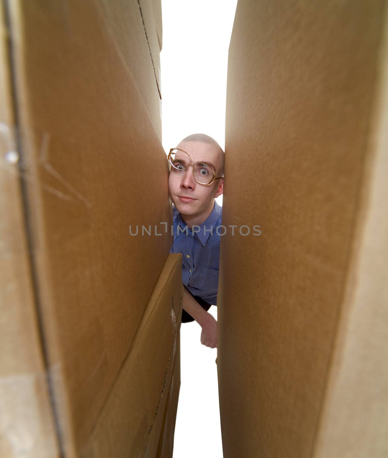 Male face clamping between walls from cardboard boxes