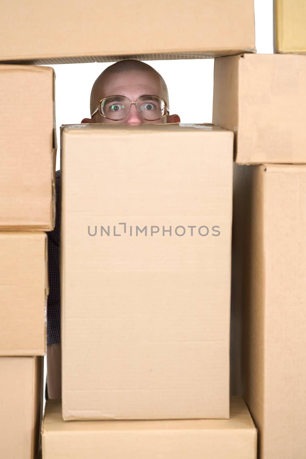 Man looking through window in pile of cardboard boxes