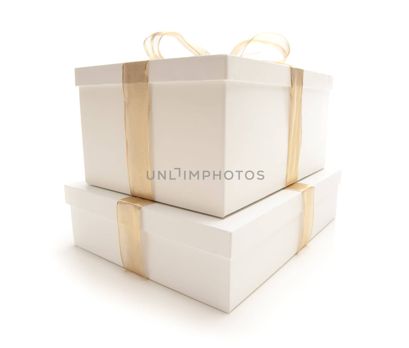 Stacked White Gift Boxes with Gold Ribbon and Bow Isolated on a White Background.