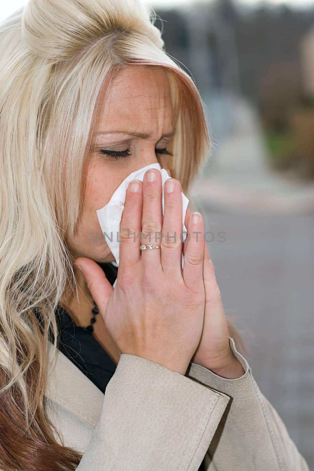 This young woman sneezing into a tissue either has a cold or really bad allergies.