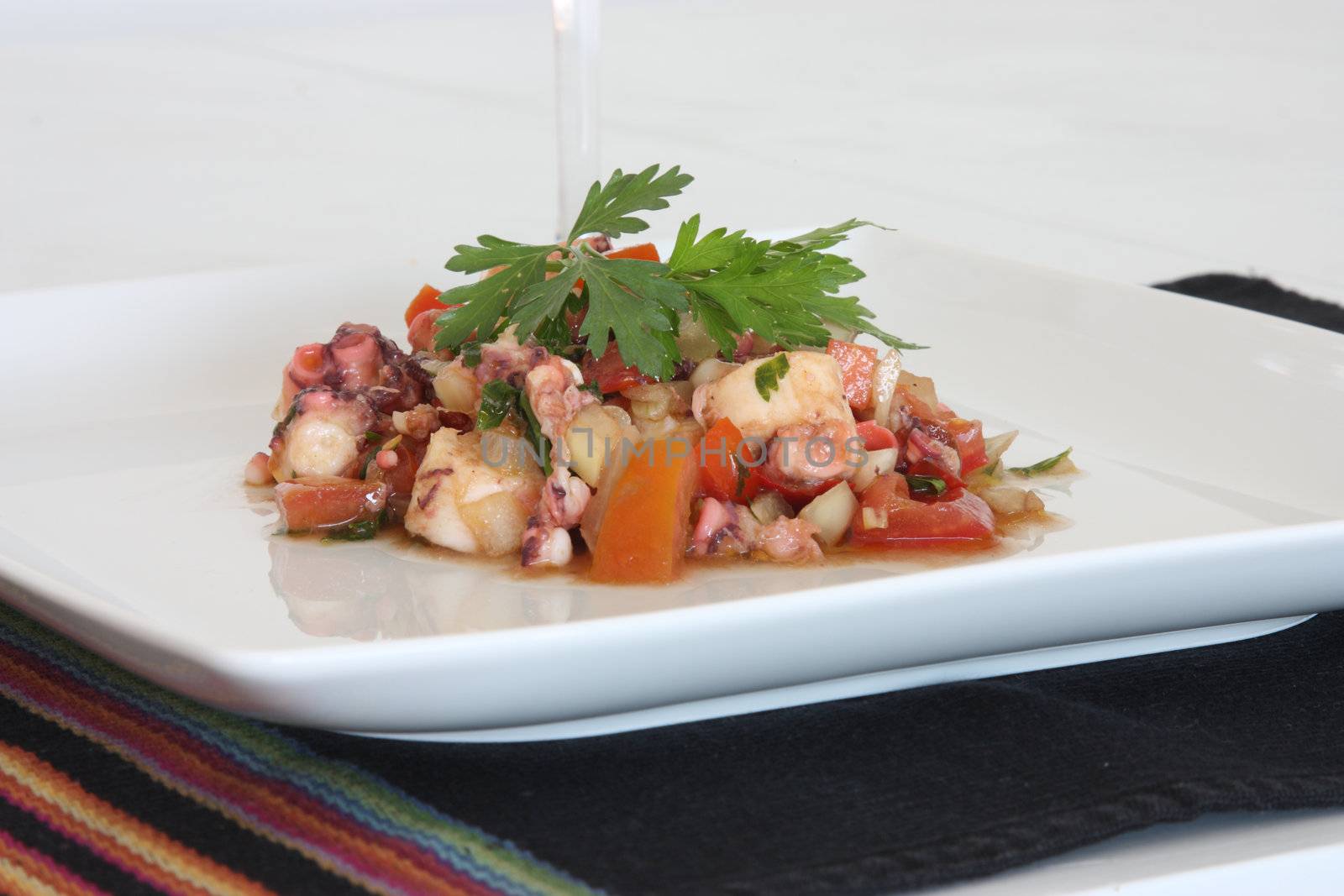 Octopus salad with peppers, onion and tomatos, with olive oil and vinegar.