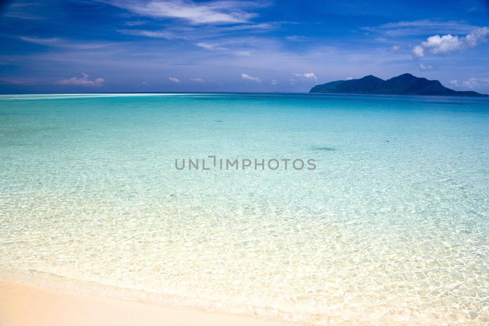Image of a remote Malaysian tropical island beach with deep blue skies and crystal clear waters.