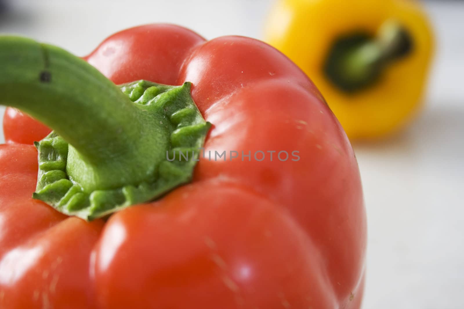 A red and a yellow pepper on Mable Background