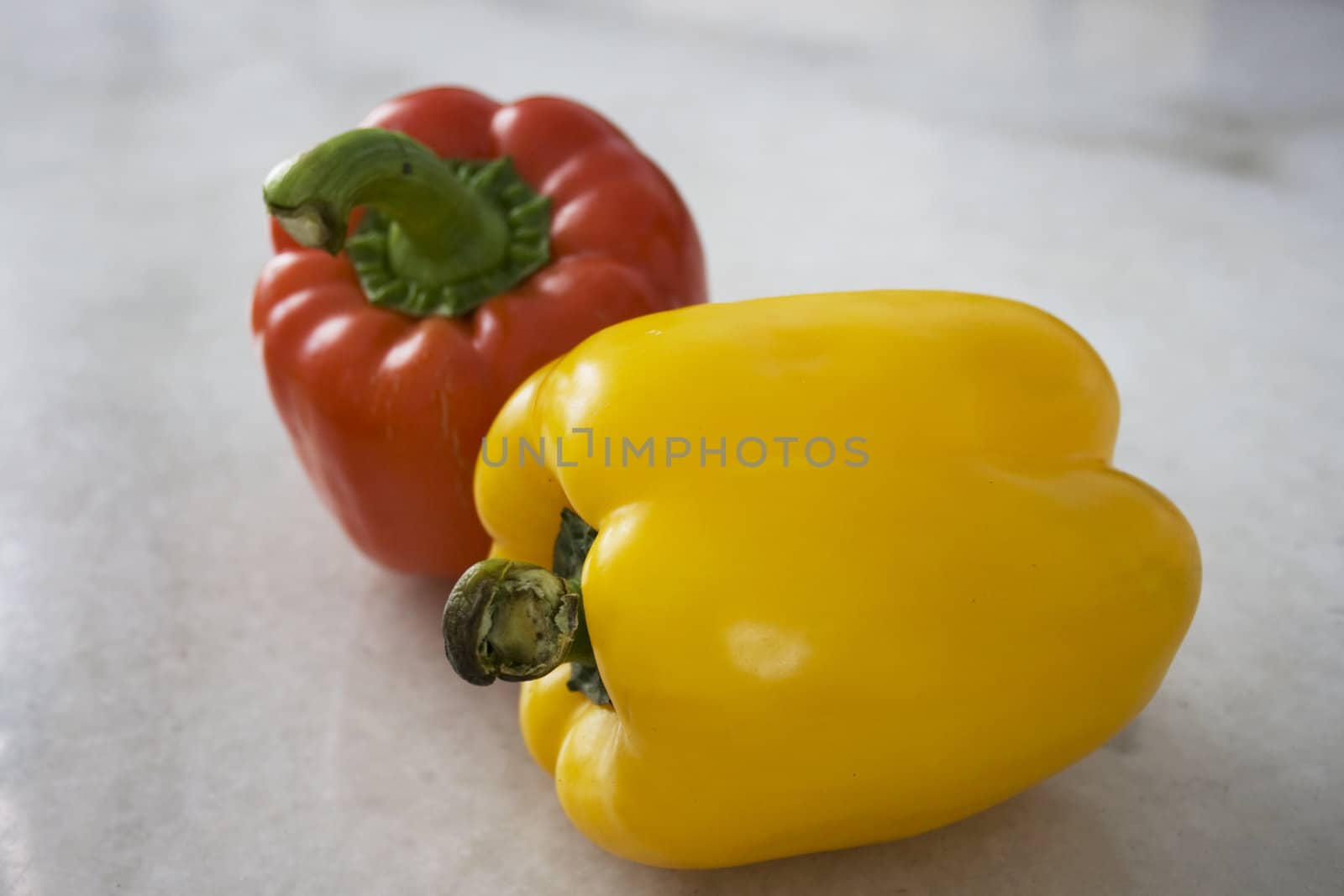 A red and a yellow pepper on Mable Background
