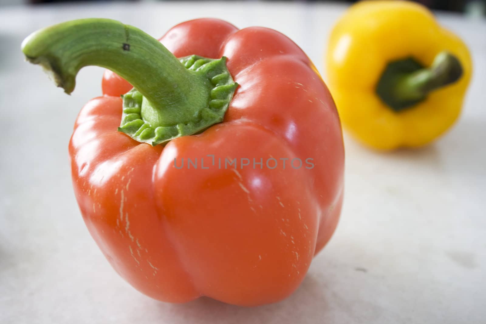 A red and a yellow pepper on Mable Background