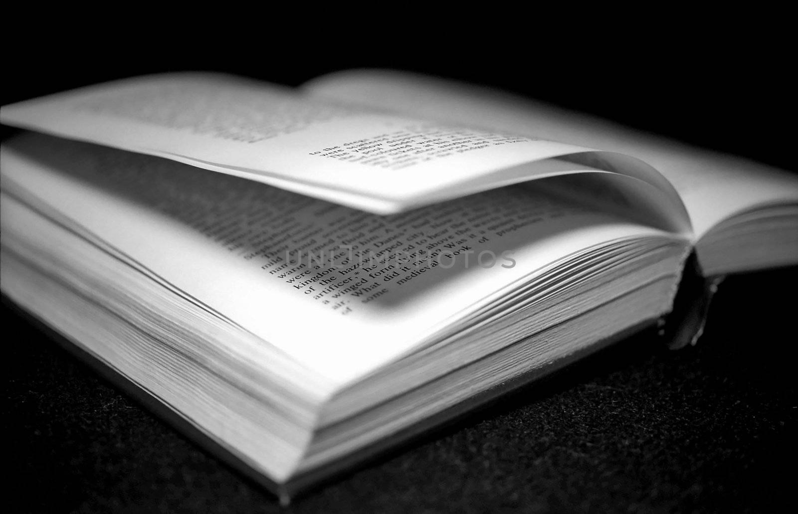 Open book on black background monochrome