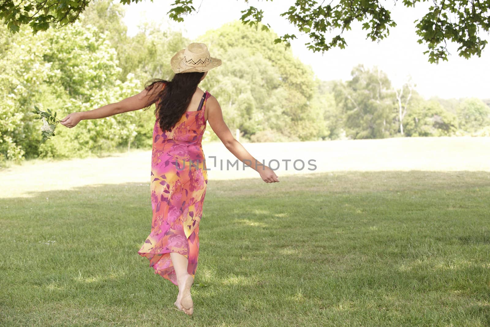young attractive woman walking away from camera with arms outstretched  