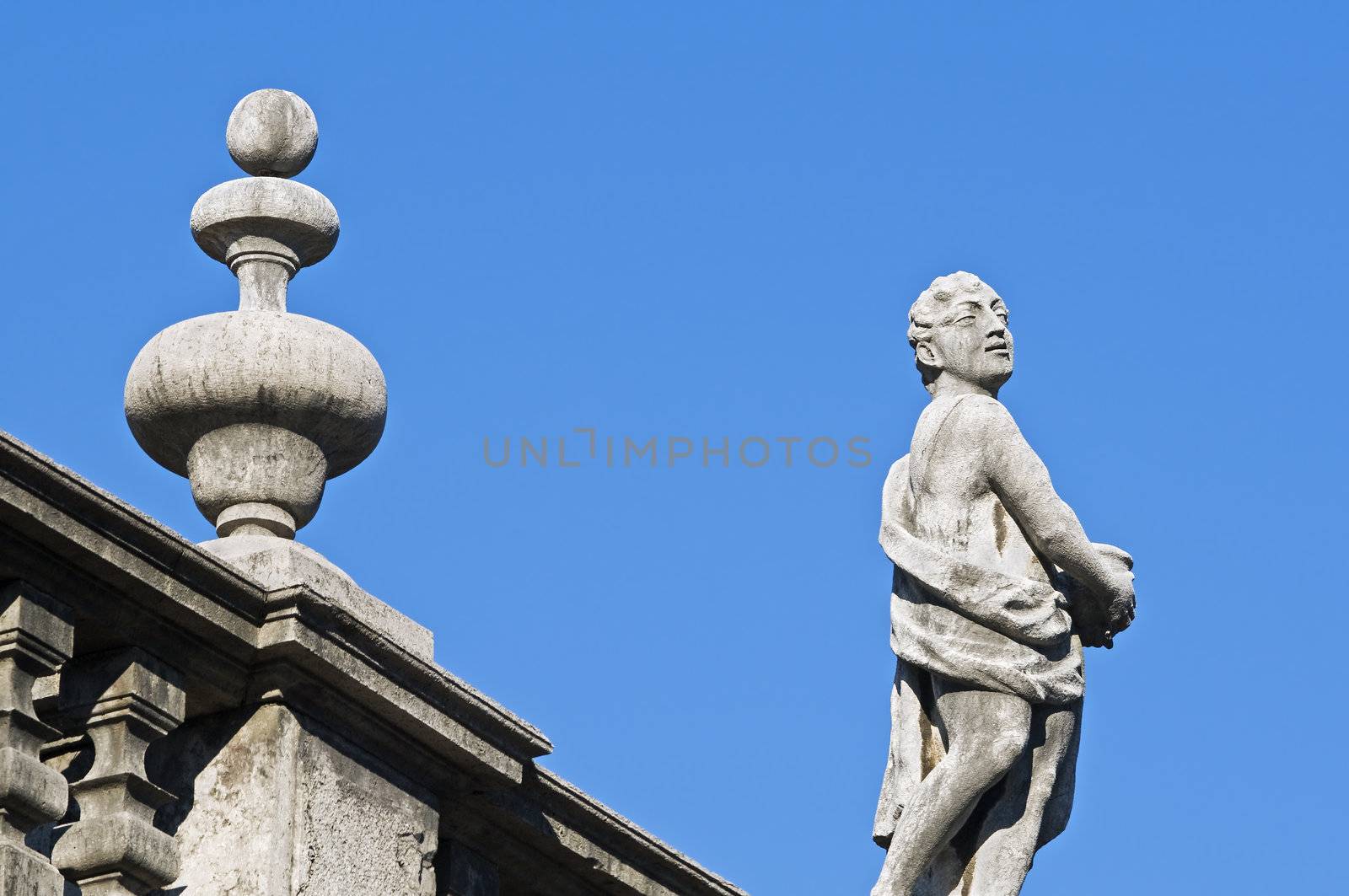 Statue on nd frieze on a building rooftop