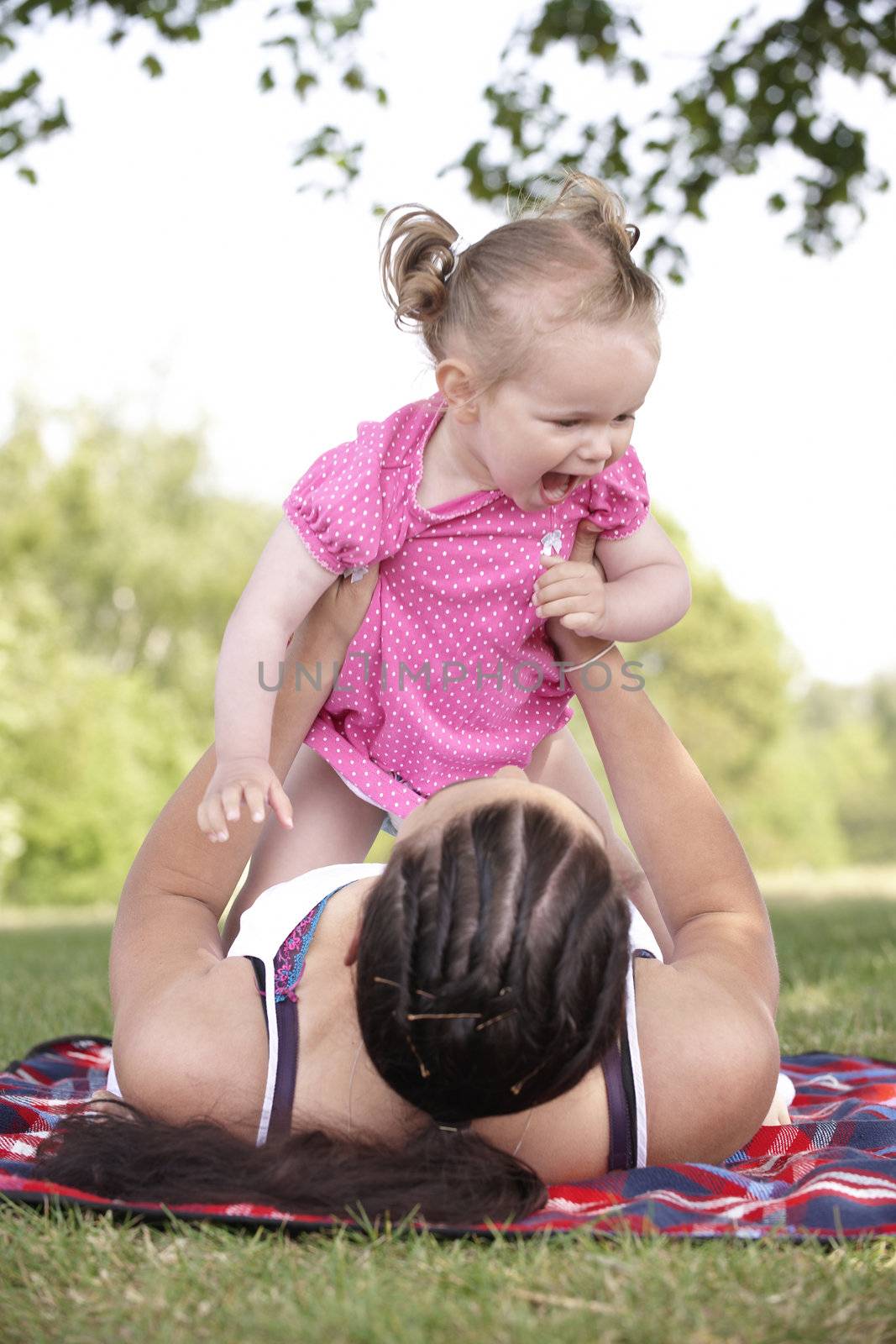 mother playing with daughter in the park in summer