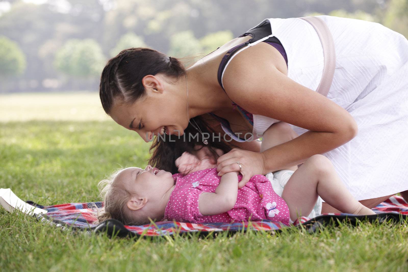 mother playing with daughter in the park in summer