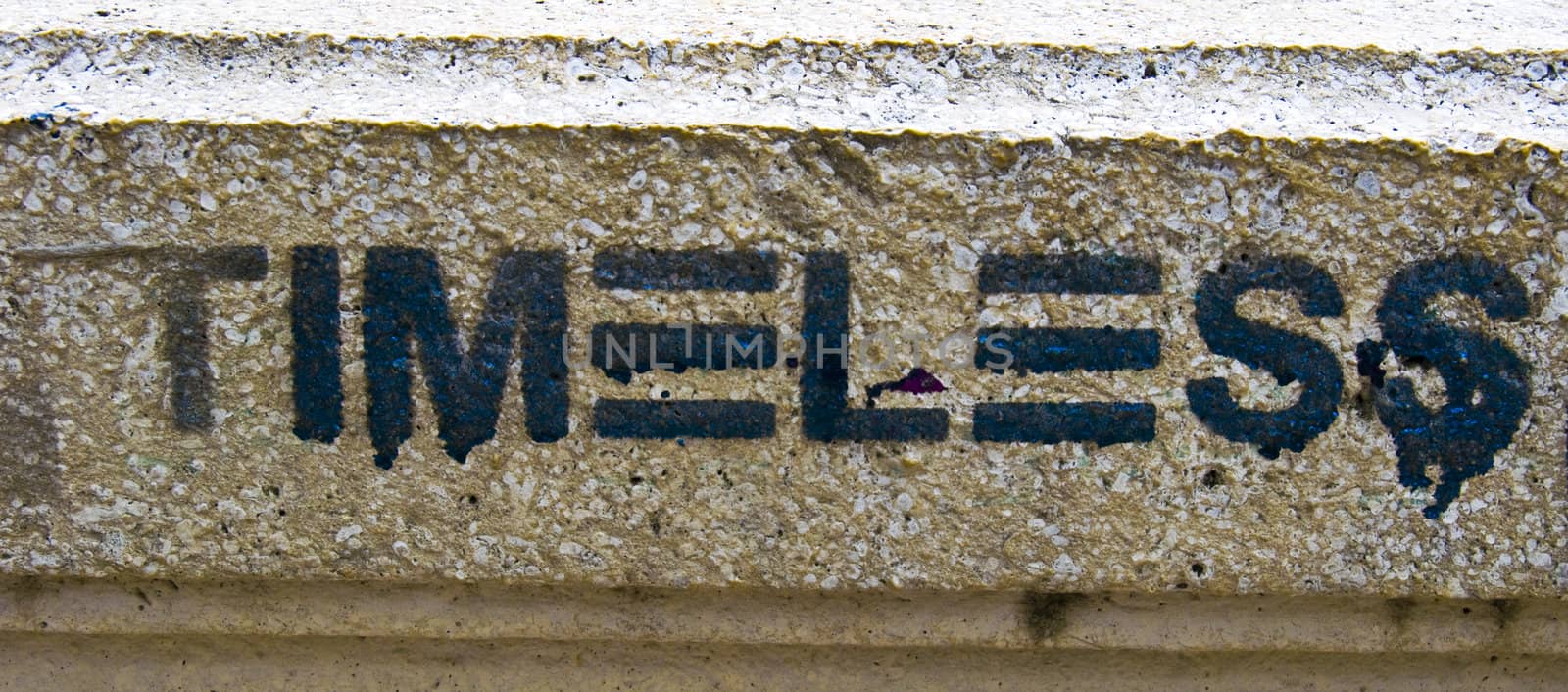 graffiti of the word timeless on a brown wall