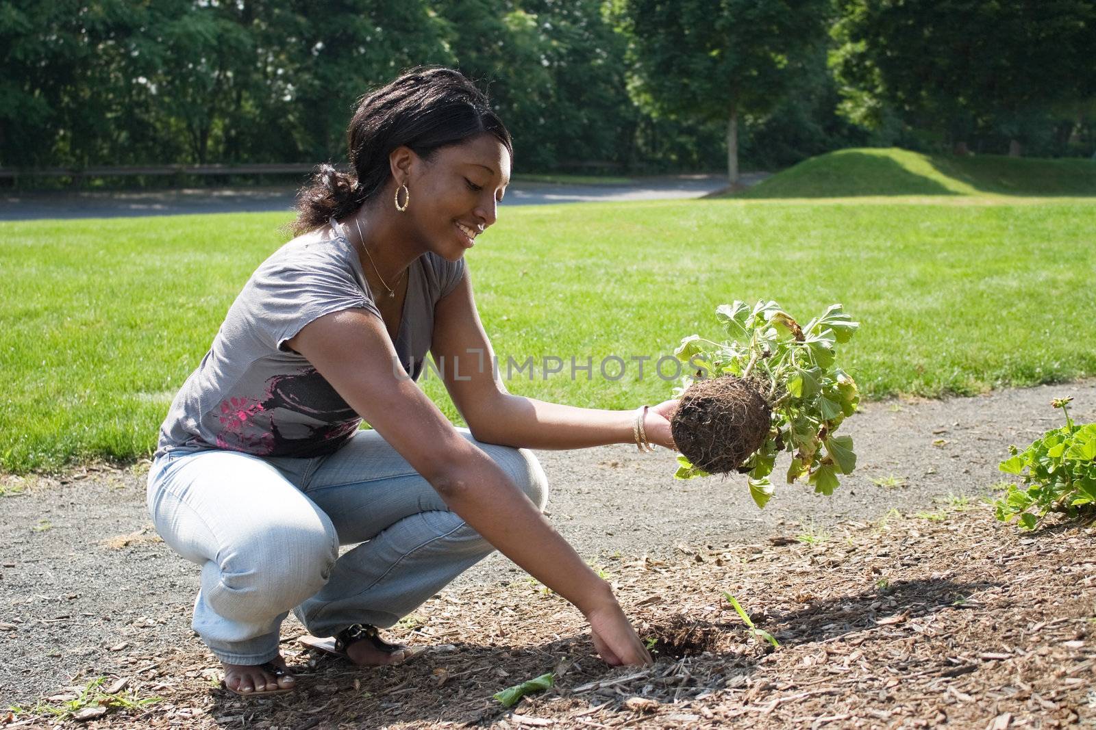 A young woman planting in her garden.