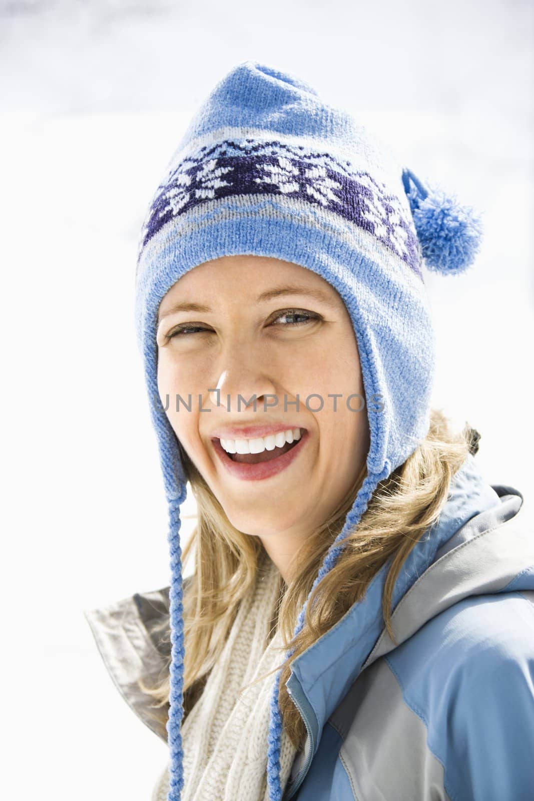 Portrait of attractive smiling mid adult Caucasian blond woman wearing blue ski cap looking at viewer.