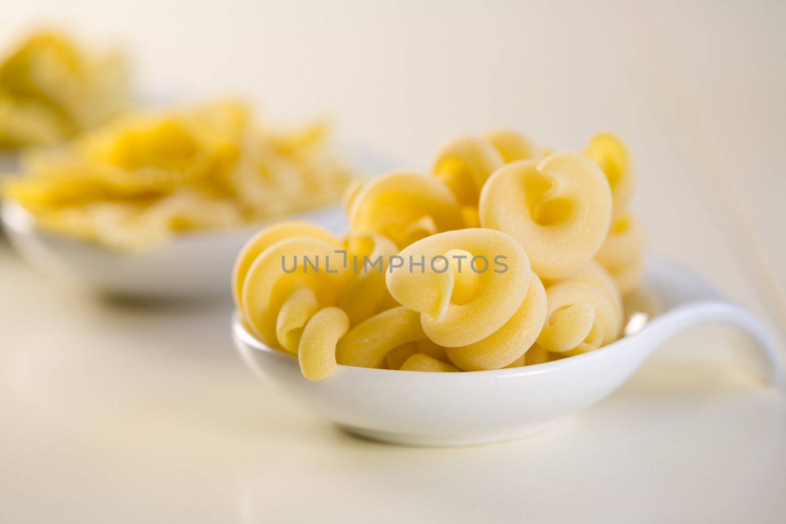 Curled up pasta in a little bowl uncooked