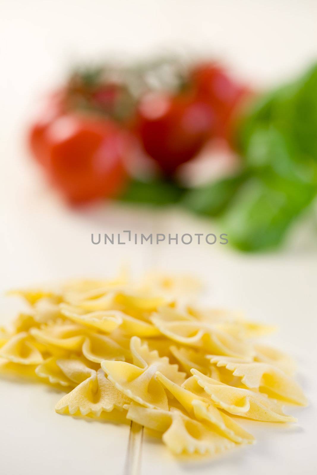 Pasta in the shape of a butterfly with vegetables in the background