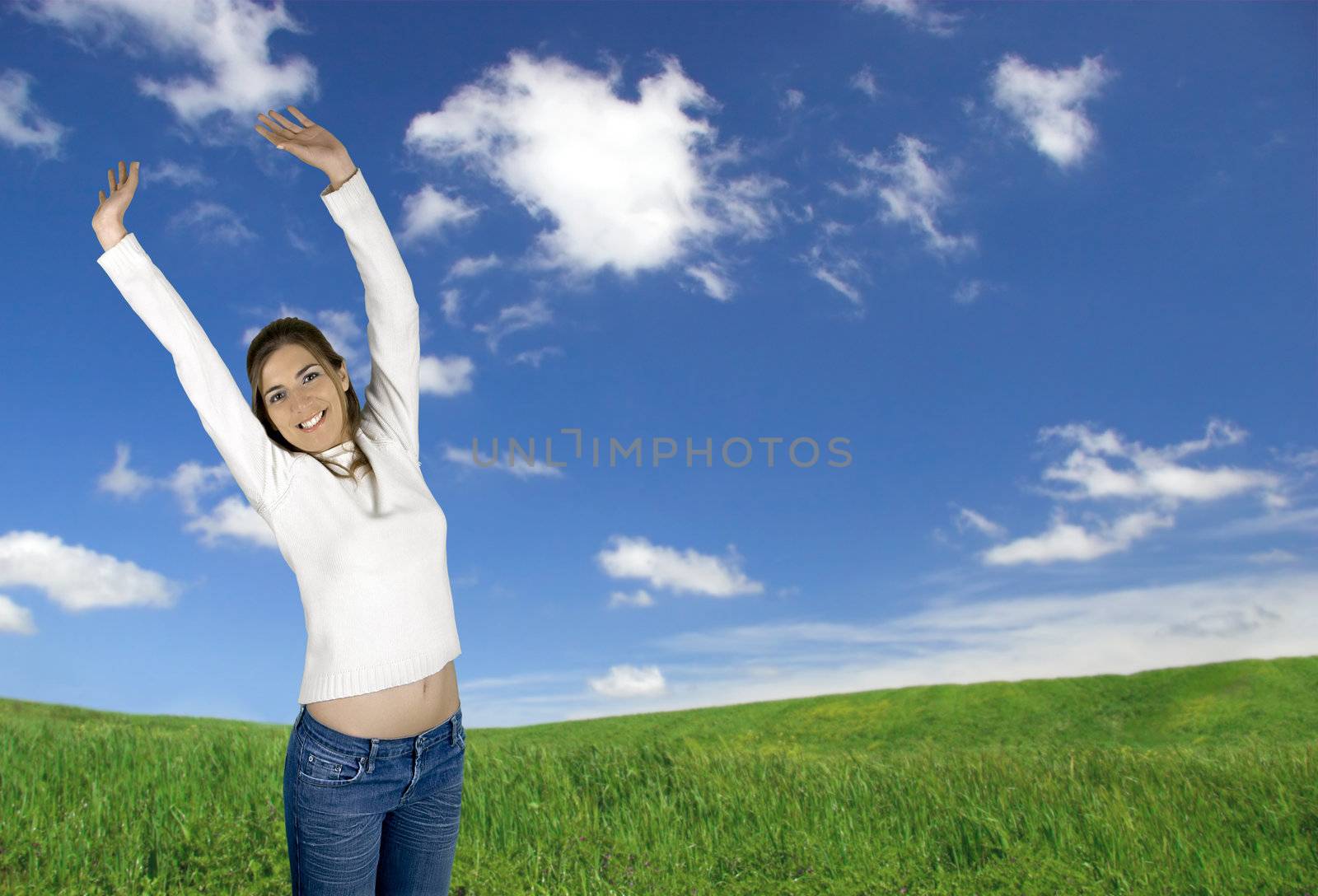 Beautiful young woman on a green landscape with a great sky